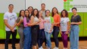 Professora e alunos na frente do ônibus institucional